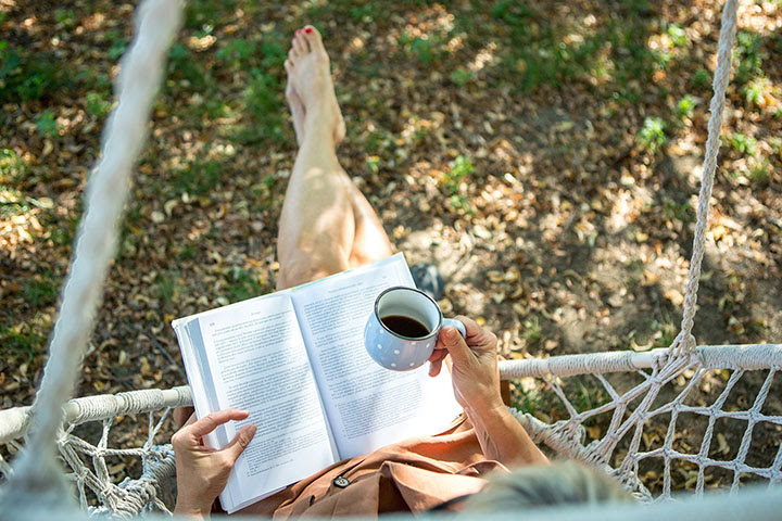 Mujer bebiendo café leyendo un libro
